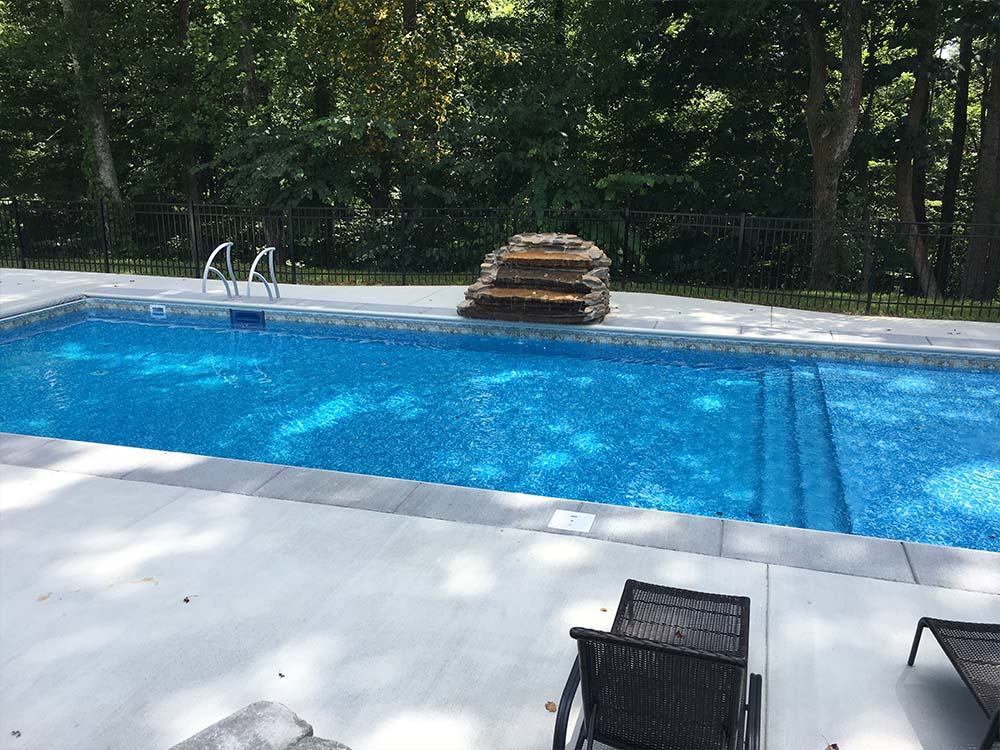 Custom-shaped vinyl pool with surrounding landscaping